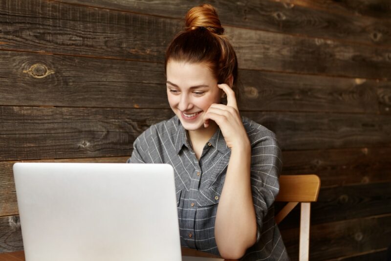 femme sur son pc souriante