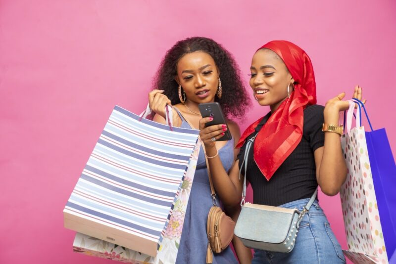 2 femmes note un magasin sur un smartphone