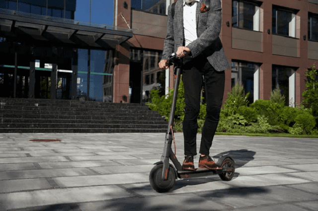 un homme conduisant une trottinette électrique